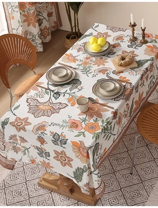 Detail of a thick linen-textured tablecloth featuring vintage floral prints in warm colors