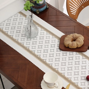 Modern white table runner with grey geometric diamond pattern and woven tassel edges