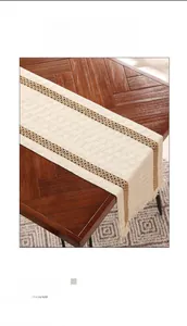 Dettaglio del runner da tavola in tessuto beige con strisce marroni e frange
