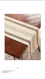 Gros plan sur un chemin de table en lin beige à rayures avec glands tissés à la main