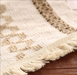 Gros plan d'un chemin de table en lin rayé kaki avec texture tissée et franges