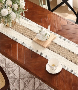 Close-up of bohemian table runner with crochet lace and brown woven jute center strip