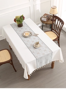 Close-up of rectangular tablecloth with European floral runner and elegant fringe trim