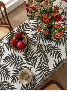 Detail of Nordic tropical palm leaf tablecloth with stylish black decorative tassels