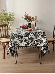 Detail of Nordic cotton linen tablecloth with black leaf print and decorative fringes