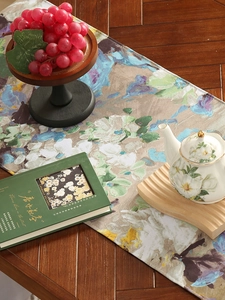 Artistic impressionist table runner with purple floral pattern on a dark wood table