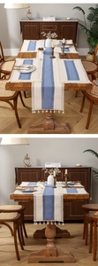 Detailed close-up of cotton linen table runner with blue hollow knit and tassel fringe