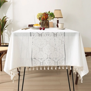 White lace tablecloth with floral jacquard and fringe edges in a cozy home setting