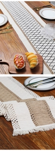 Close-up of bohemian linen table runner with woven tassels and crochet lace detail