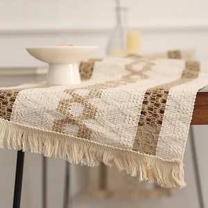 Chemin de table tissé bohème avec motifs en losange et franges sur table en bois