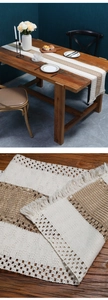 Detailed macro view of woven beige linen table runner with fringes and textured stripes
