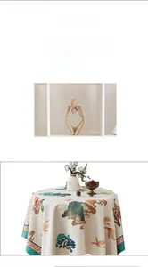 Close-up of beige linen tablecloth with Chinese crane patterns and green piping