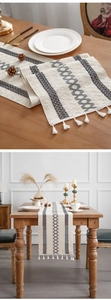 Detailed macro view of woven geometric patterns and soft cotton tassels on table runner