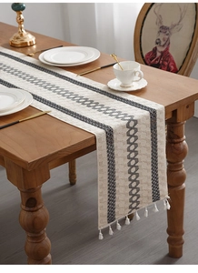 Detail of woven cotton linen table runner with tassel accents and geometric patterns