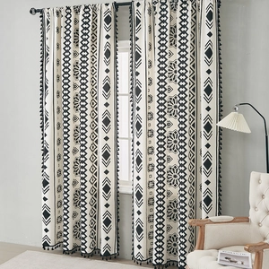 Dettaglio della tenda bohémien con motivo geometrico bianco e nero e frange a pompon