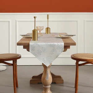 Elegant silver white jacquard table runner with floral patterns and luxury tassel detail