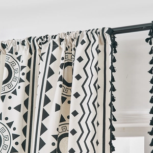 Dettaglio della tenda bohémien in cotone lino con motivi geometrici e nappe laterali