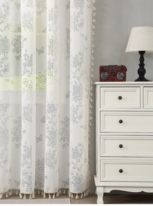 Detail of white French lace curtain with retro butterfly patterns and fringe tassels