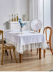 Detail of white rectangle tablecloth showing floral embroidery, lace edge and waterproof fabric