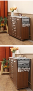 Close-up detail of a dark brown wooden sideboard with four drawers and vintage metal handles