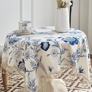 Detailed macro shot of blue floral cotton linen tablecloth with handmade woven tassels
