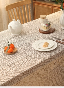 Close-up of bohemian lace tablecloth featuring floral crochet patterns and tassel fringe