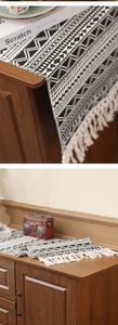 Detail of woven table runner featuring black and white geometric patterns and boho tassels