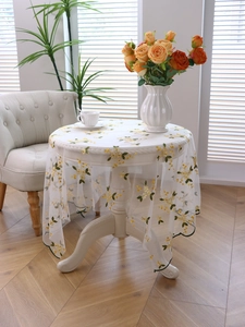 Close-up of delicate floral lace tablecloth with embroidery and green wavy edges