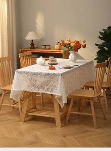 Close-up of white lace tablecloth with vintage floral hollow embroidery and tassels