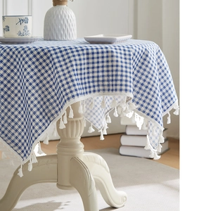 Detail of blue and white plaid cotton linen tablecloth with elegant white fringe edges