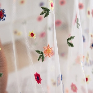 White lace mesh tablecloth with colorful floral embroidery for decorative settings