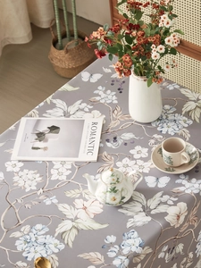 Close-up of vintage floral tablecloth with butterflies and elegant afternoon tea setup