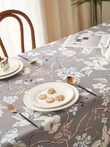 Detail of vintage floral tablecloth with grey base and elegant linen texture in a dining scene