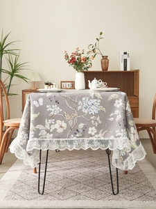 Detail of floral tablecloth with grey print and wide vintage white lace edge trim