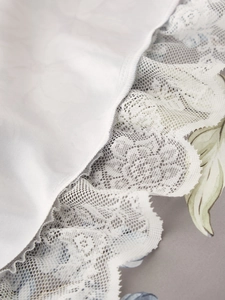 Close-up of elegant white lace borders and intricate hollow embroidery on fabric