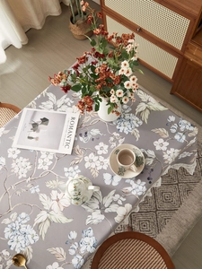 Close-up of vintage floral tablecloth with grey base and delicate white lace edges