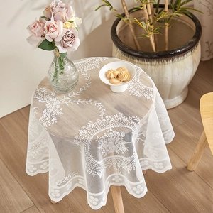 Elegant white round lace tablecloth with floral hollow patterns and scalloped edges