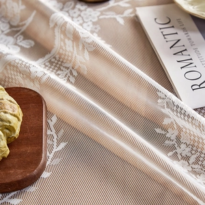 Elegant white lace tablecloth with vintage floral patterns on a warm wooden background