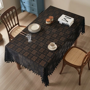 Detail der schwarzen Häkelspitze-Tischdecke mit eleganten Fransen und Durchbruchmuster