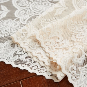 Close-up of elegant floral lace fabric with scalloped edges and intricate texture