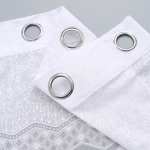 White lace sheer curtain header with silver metal grommets and delicate mesh texture