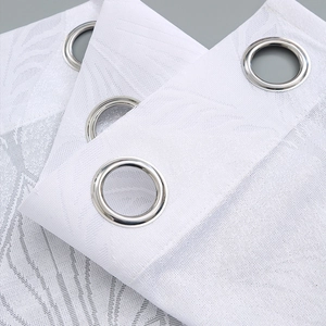 Close-up of white lace sheer curtain with silver metal eyelets and leaf vein texture