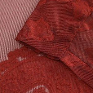 Detail of dark red polyester lace window curtain with floral embroidery and wavy hem