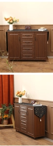 Detail of Nordic table runner on dark wood sideboard with metal handles and wood grain