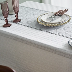 Macro view of French linen tablecloth featuring jacquard texture and lace splicing details