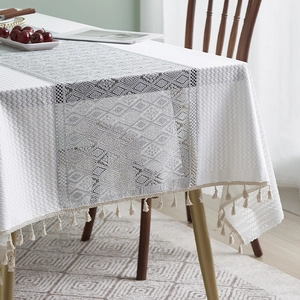 Detail of French cotton linen tablecloth with cream tassels and gray jacquard texture