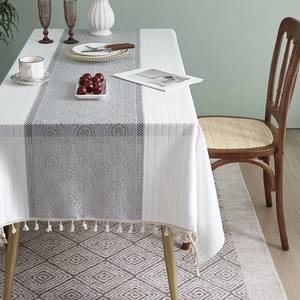 Detail of French cotton linen tablecloth with lace stitching and elegant fringe trim
