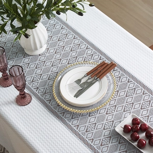 Elegant grey hollow geometric table runner with woven texture on a dining table