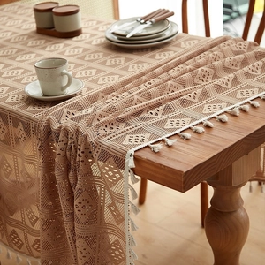 Pastoral lace tablecloth with hollow diamond pattern and white tassels on a wooden table