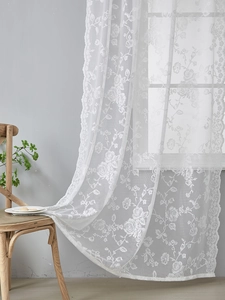 Detail showing white lace curtain with rose floral embroidery and scalloped edges